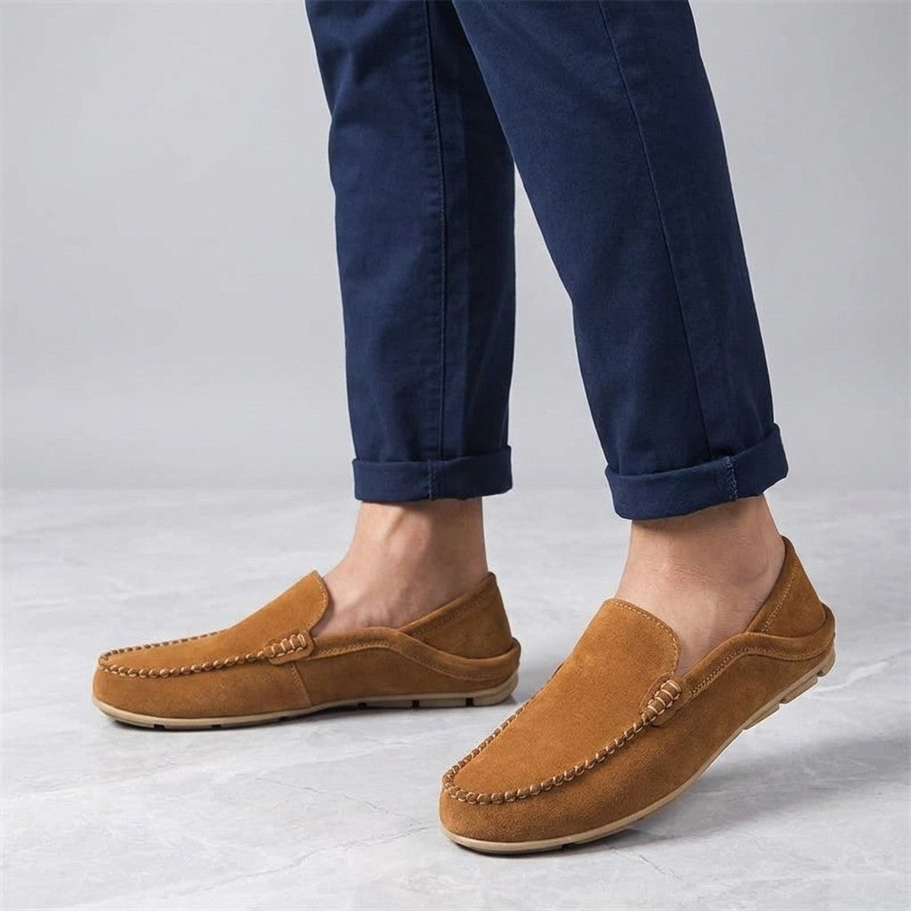 Cervia Suede Loafers — Apricot, worn sockless with cuffed navy chinos, knee-down on light grey marble