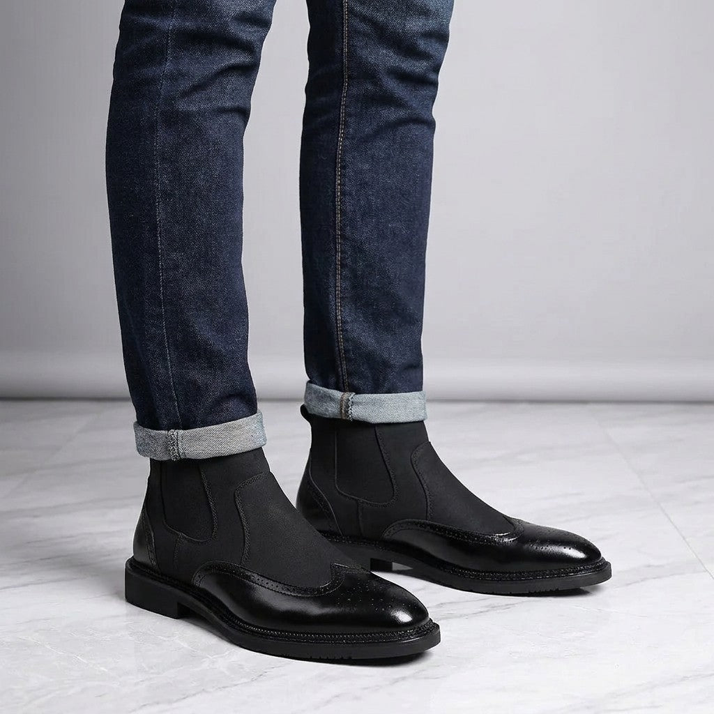 Dozza Brogue Chelsea Boots — Black, worn with cuffed dark jeans, knee-down on light grey marble