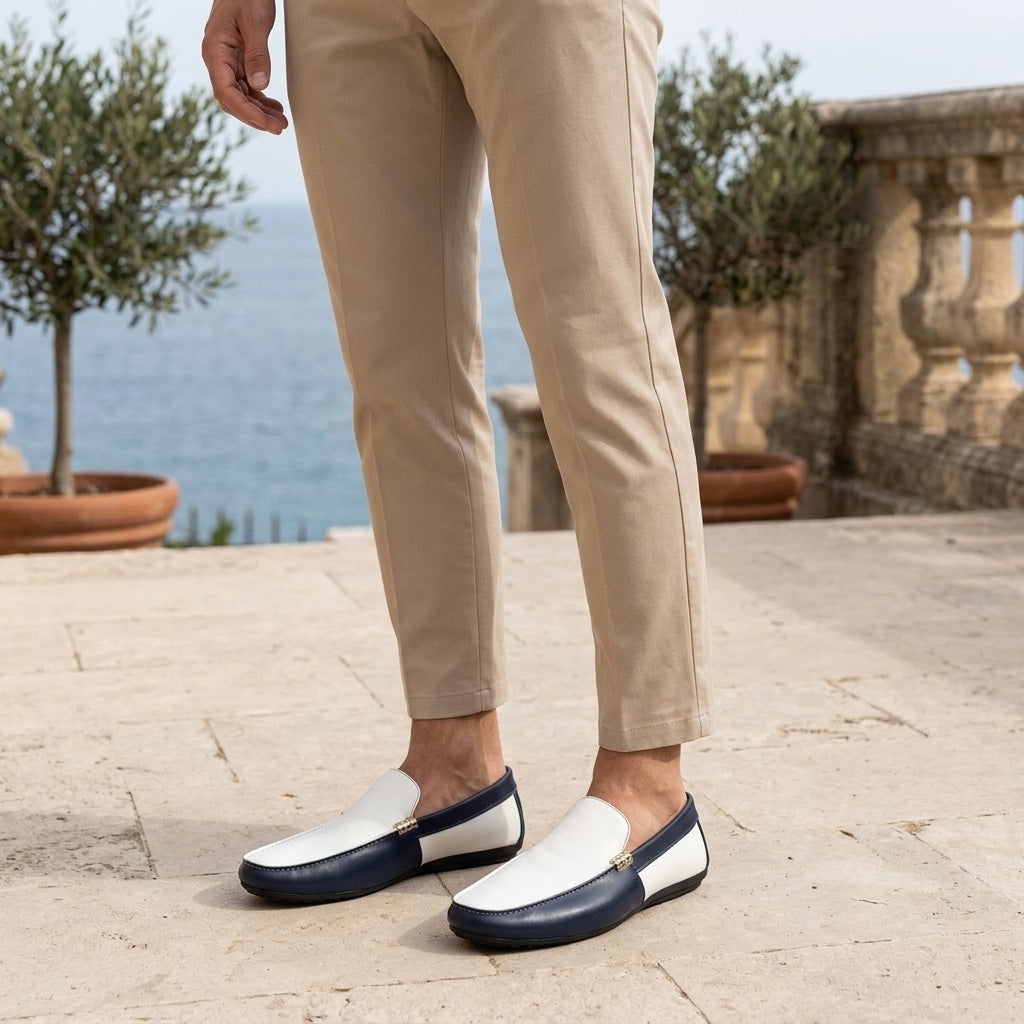 Stresa Two-Tone Loafers — Navy & White, worn on a coastal stone terrace