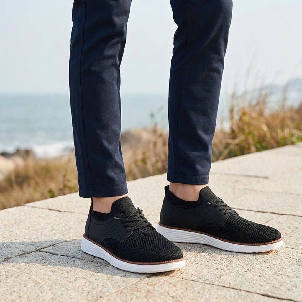 Formia Mesh Sneakers — Black, knee-down, restrained coastal setting, male model dark navy chinos