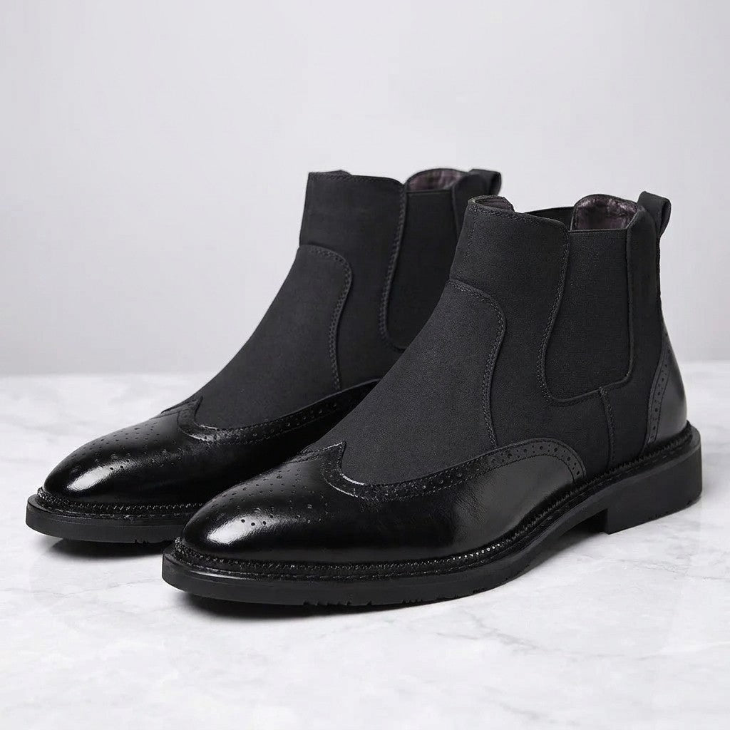 Dozza Brogue Chelsea Boots — Black, pair of Chelsea boots, three-quarter view on light grey marble